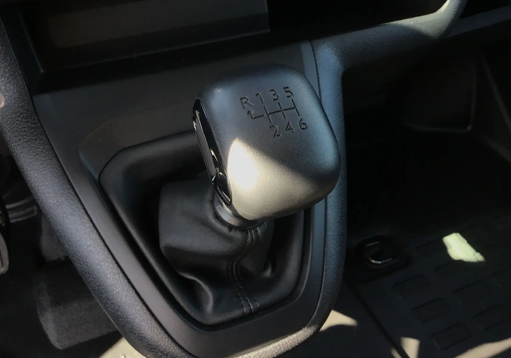 Gros plan sur le levier de vitesses manuel noir du Peugeot Expert Fourgon blanc 2025, version BlueHDi 120 Pack Connectivité.