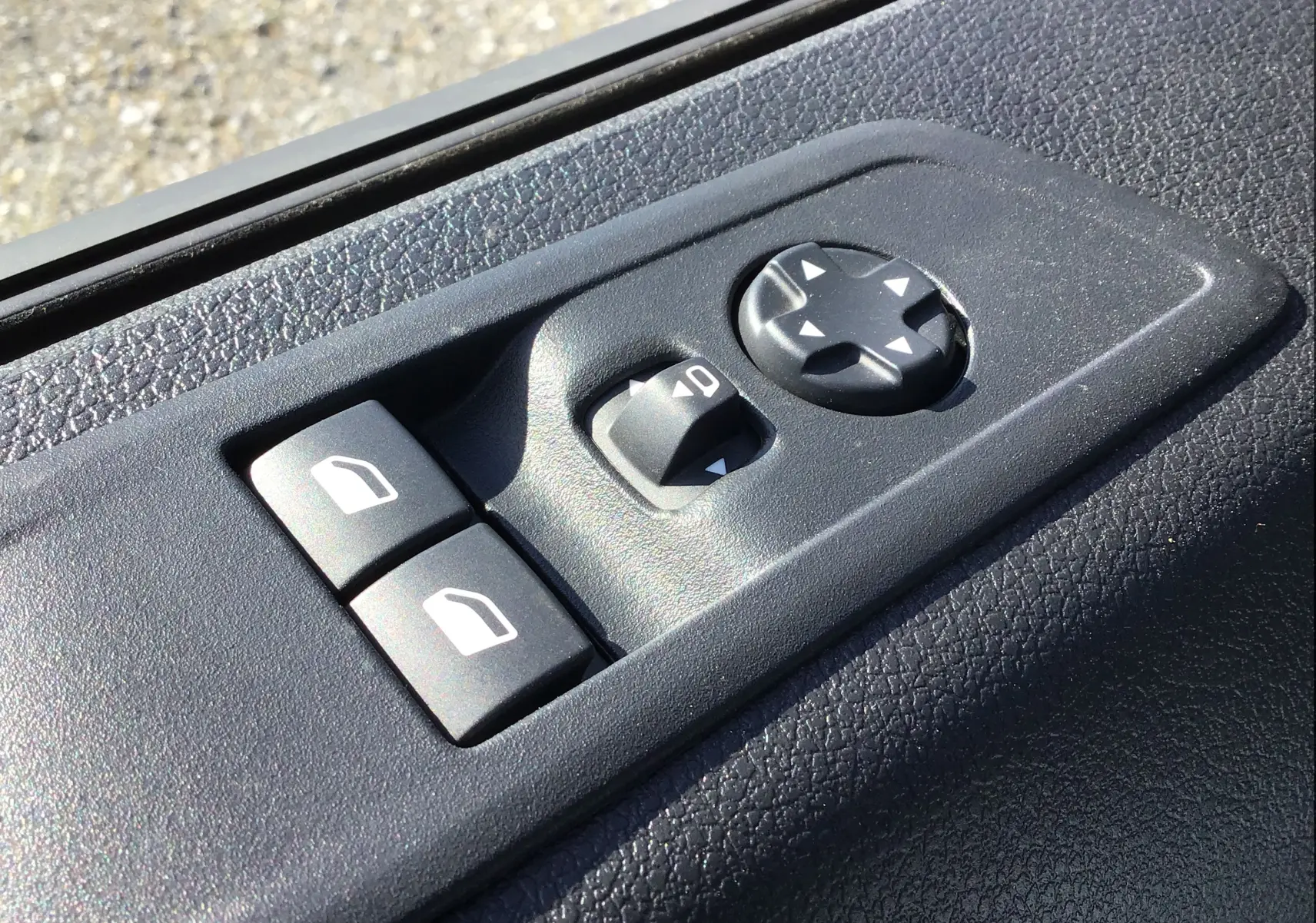 Gros plan sur les commandes électriques des vitres et rétroviseurs côté conducteur du Peugeot Expert Fourgon blanc 2025.