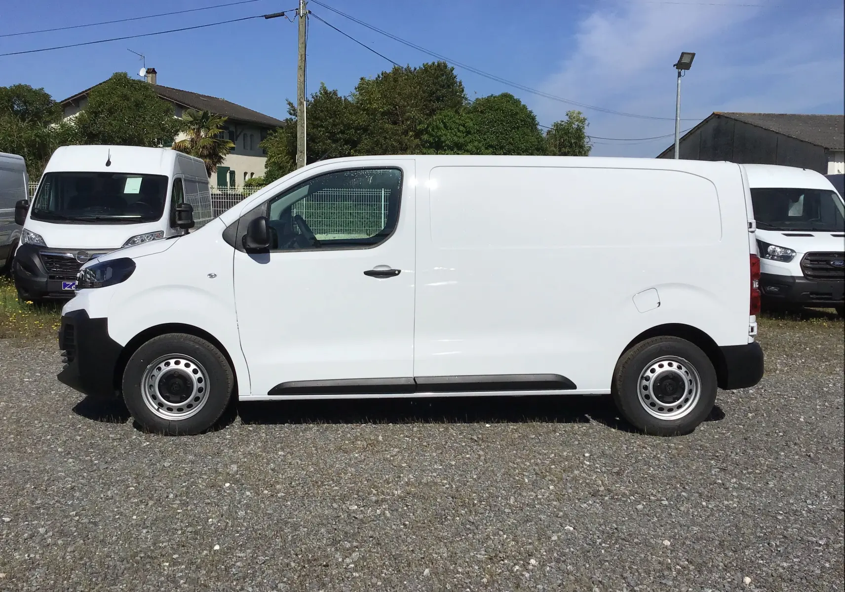 Profil côté gauche d'un Peugeot Expert Fourgon blanc 2025 avec porte latérale coulissante et jantes acier simples.