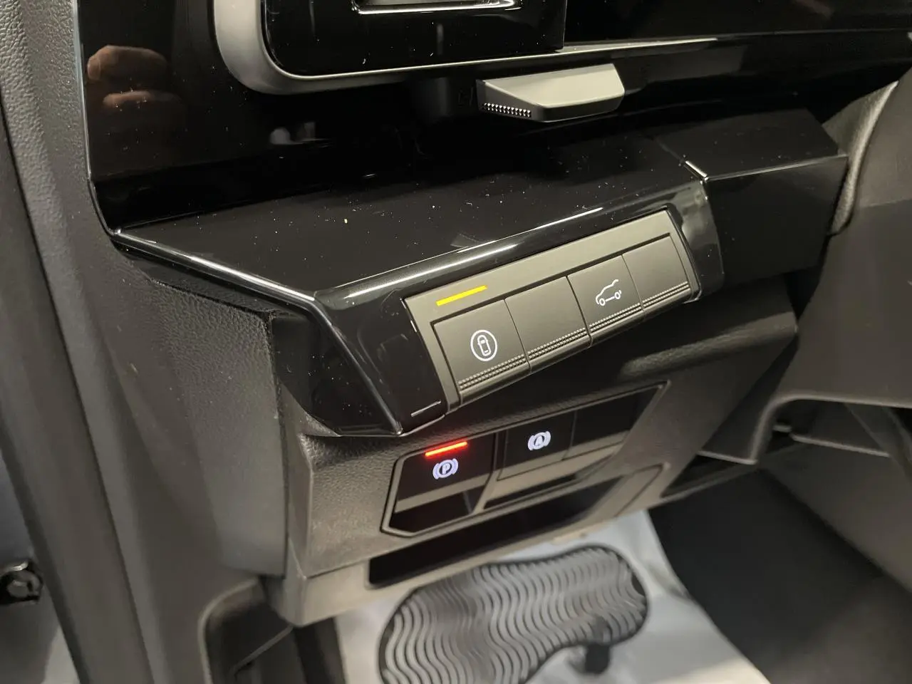 Gros plan sur la console centrale noire brillante du Renault Austral 2025, avec boutons de contrôle et éclairages LED.