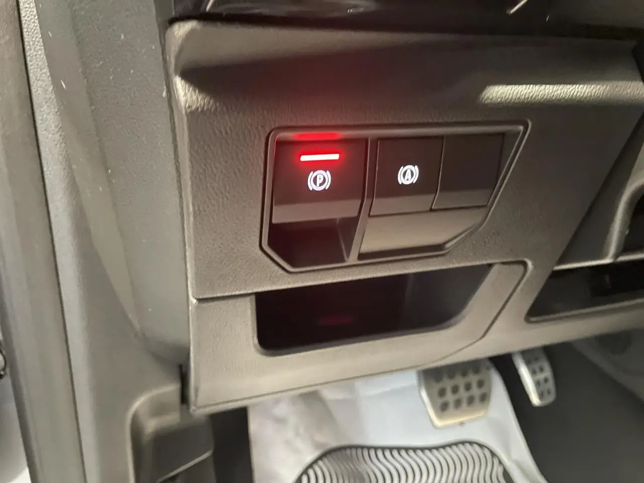 Gros plan sur les commandes du frein de parking électrique et arrêt auto, pédalier aluminium visible, intérieur Renault Austral 2025.