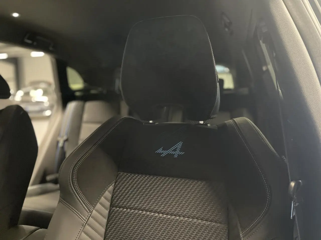 Gros plan sur le siège avant conducteur noir avec logo Esprit Alpine brodé bleu, intérieur du Renault Austral 2025.