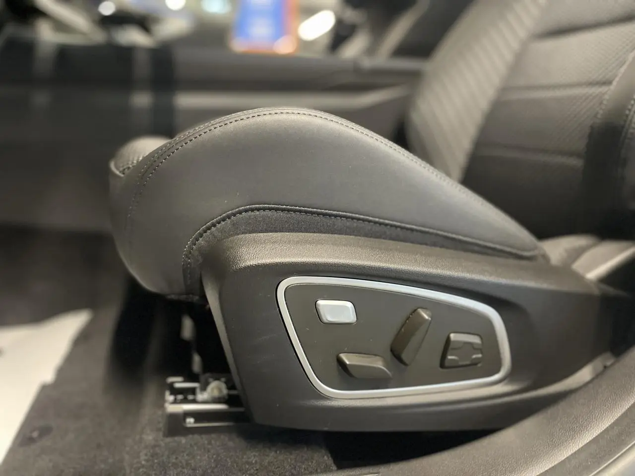 Réglages électriques du siège conducteur en cuir noir dans un Renault Austral gris métallisé, vue latérale intérieure.