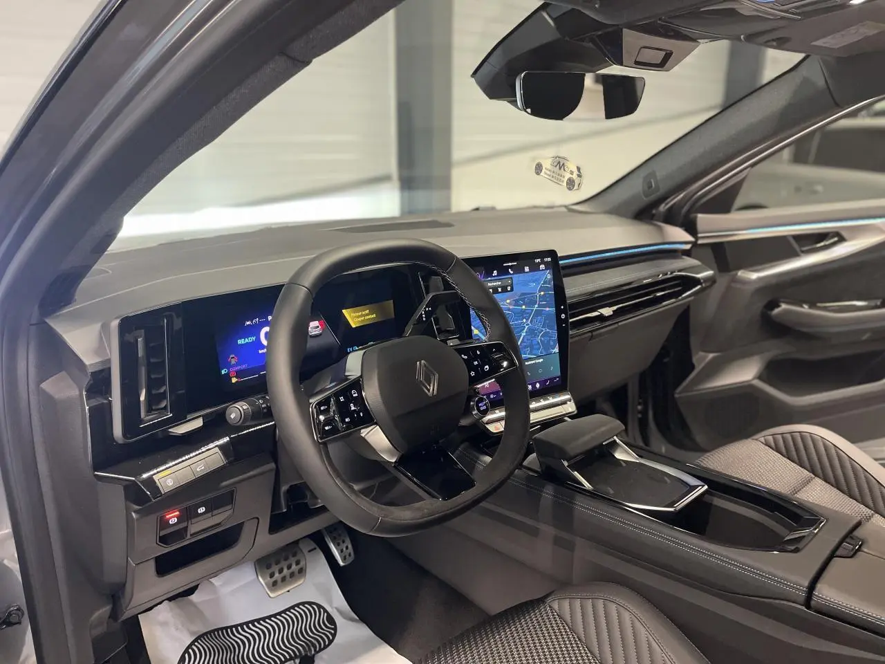 Intérieur avant droit du Renault Austral 2025 avec tableau de bord numérique et sellerie Alcantara grise.