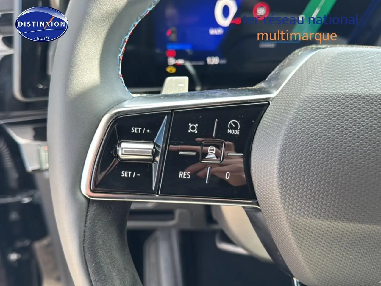 Gros plan sur le volant noir avec surpiqûres bleues du Renault Austral 2026, boutons de commande multifonction visibles.