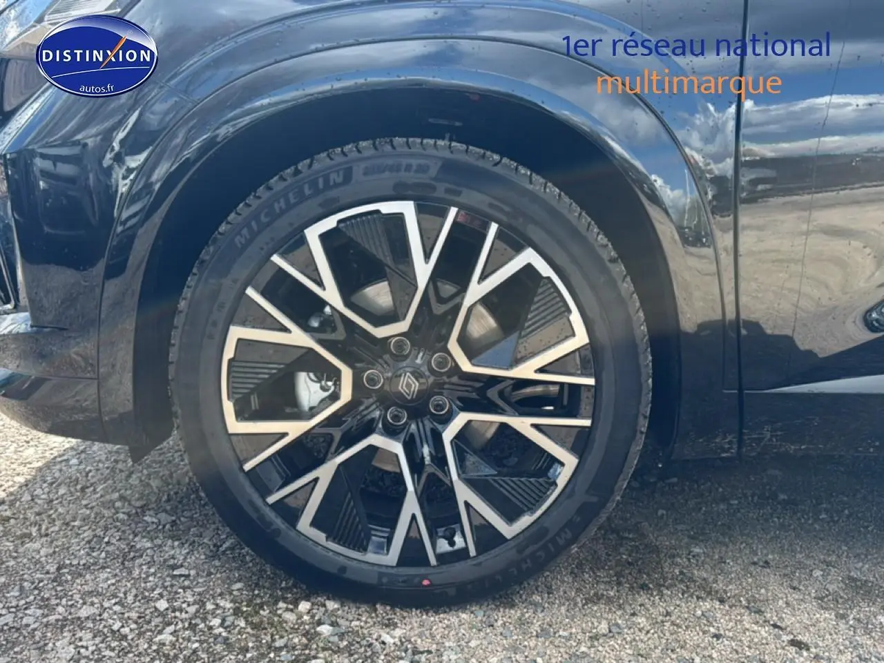 Gros plan sur la roue avant gauche du Renault Austral noir avec jante alliage 20 pouces au design géométrique.