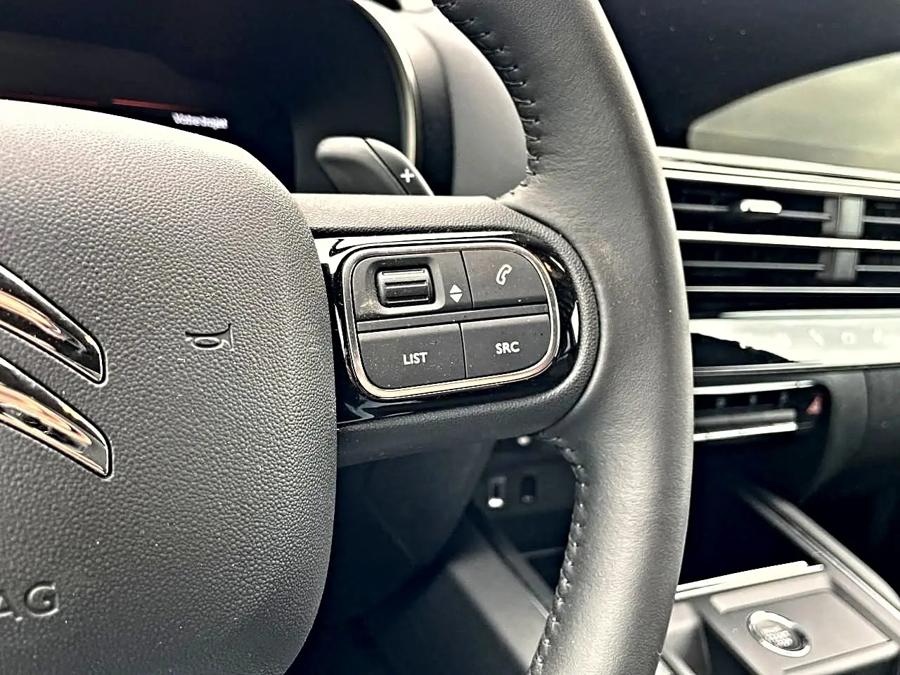 Gros plan sur le volant noir multifonction du Citroën C5 Aircross 2025, avec commandes audio et téléphone visibles.