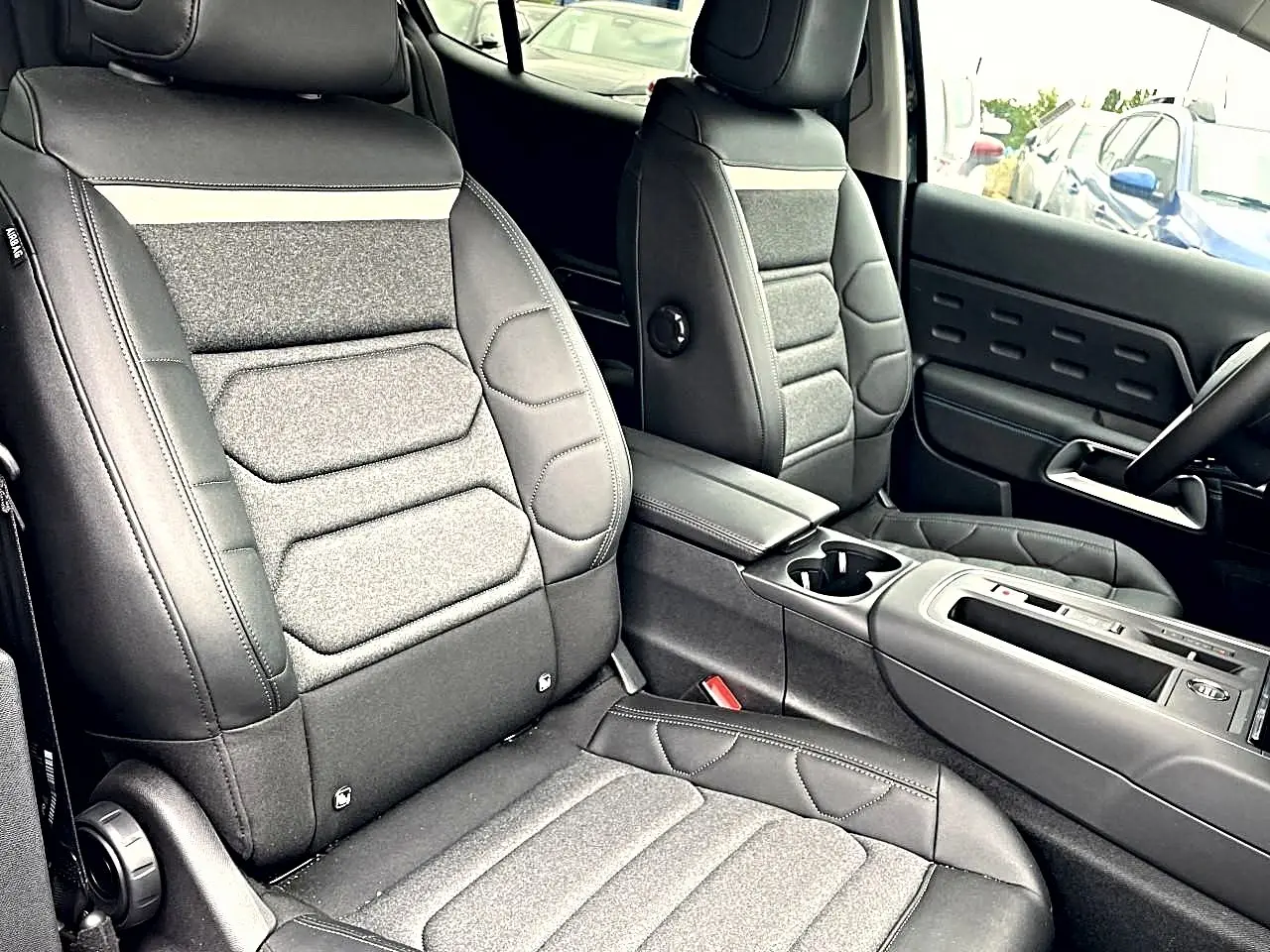 Vue intérieure rapprochée des sièges avant gris foncé et console centrale du Citroën C5 Aircross 2025.