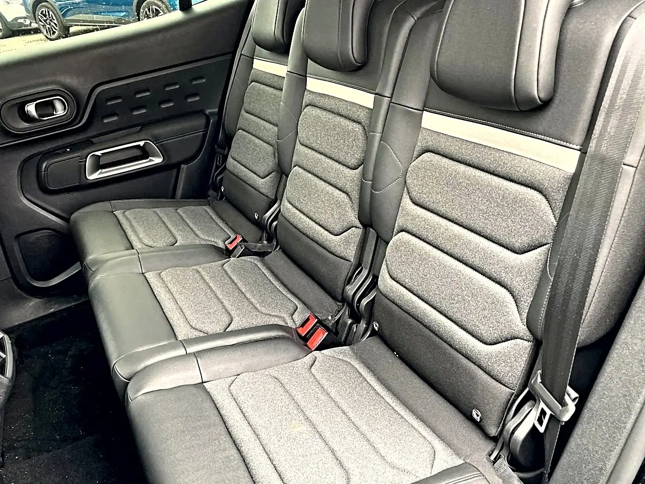 Vue latérale droite de la banquette arrière noire et grise du Citroën C5 Aircross 2025 avec ceinture de sécurité visible.