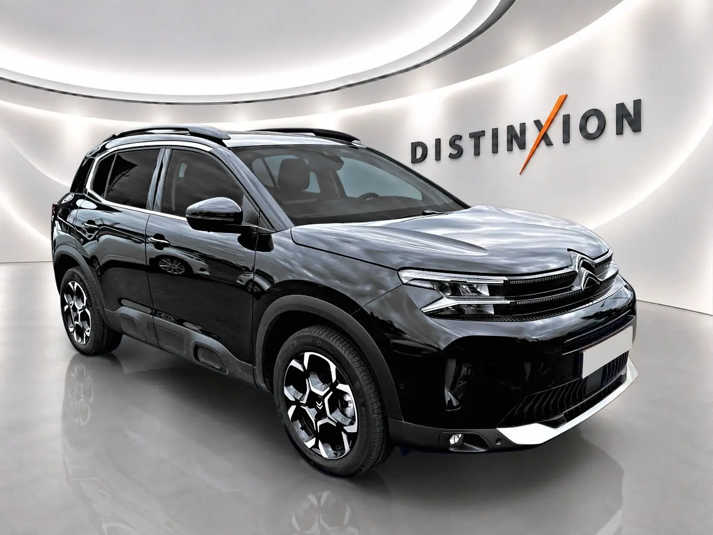 Citroën C5 Aircross noir vue 3/4 avant droit en intérieur avec jantes alu et toit noir brillant.
