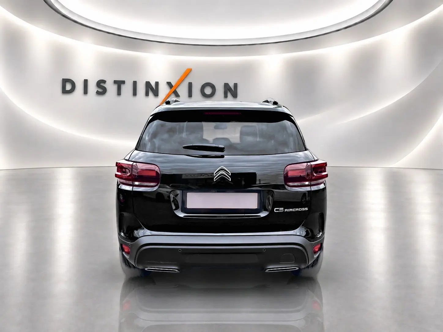 Vue arrière d'un Citroën C5 Aircross noir 2025 dans un showroom lumineux avec logo Distinxion en arrière-plan.