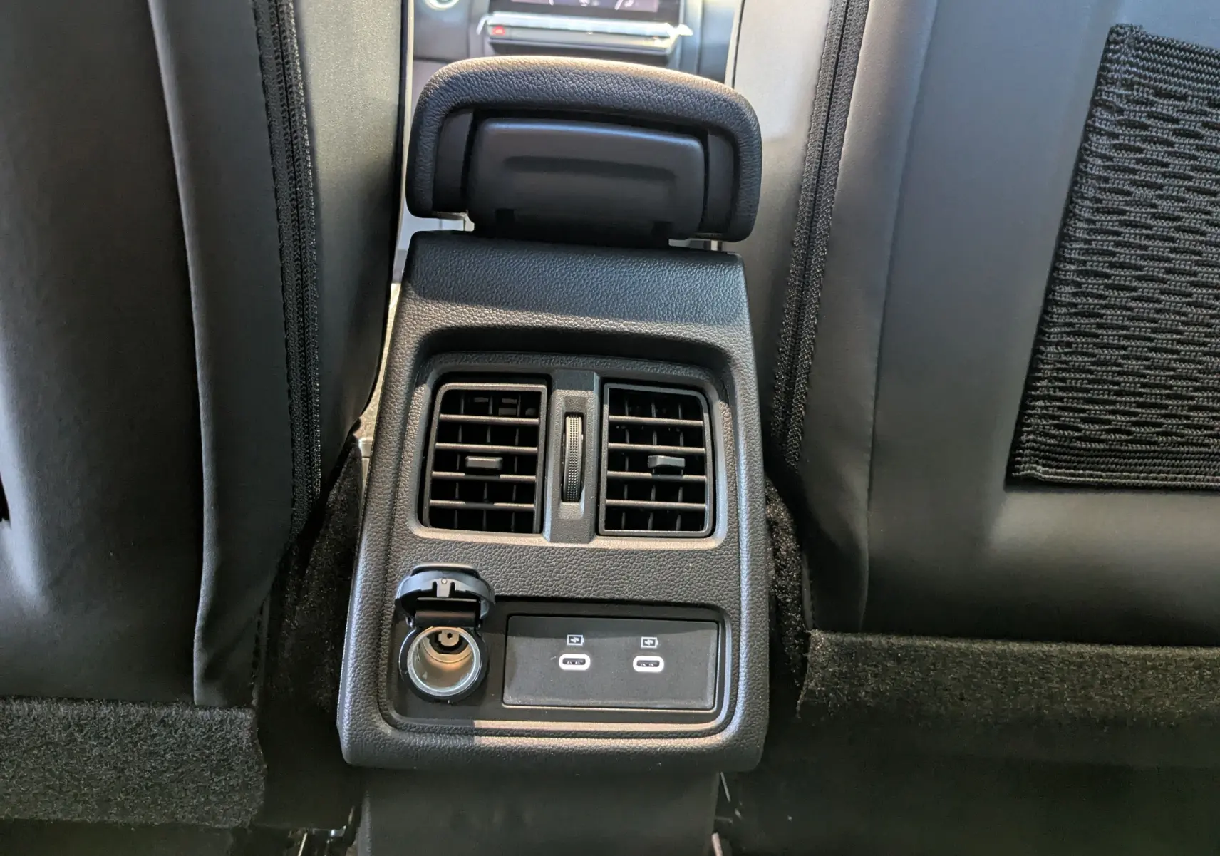 Détail de la console arrière avec prises USB et ventilation du Renault Captur E-Tech Full Hybrid 160ch en intérieur noir.