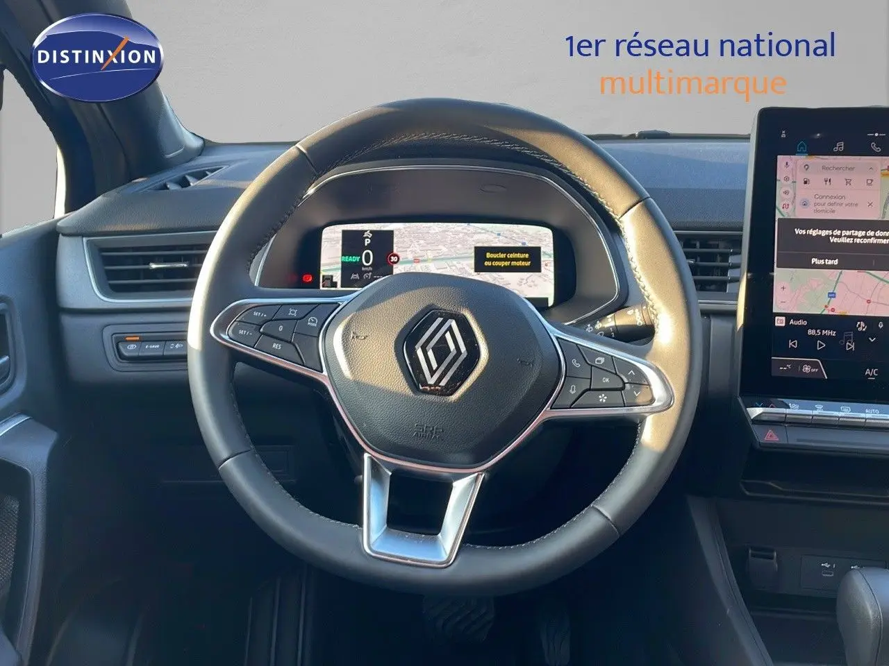 Vue rapprochée du volant noir du Renault Captur E-Tech Hybrid 2025 avec tableau de bord numérique et écran tactile.