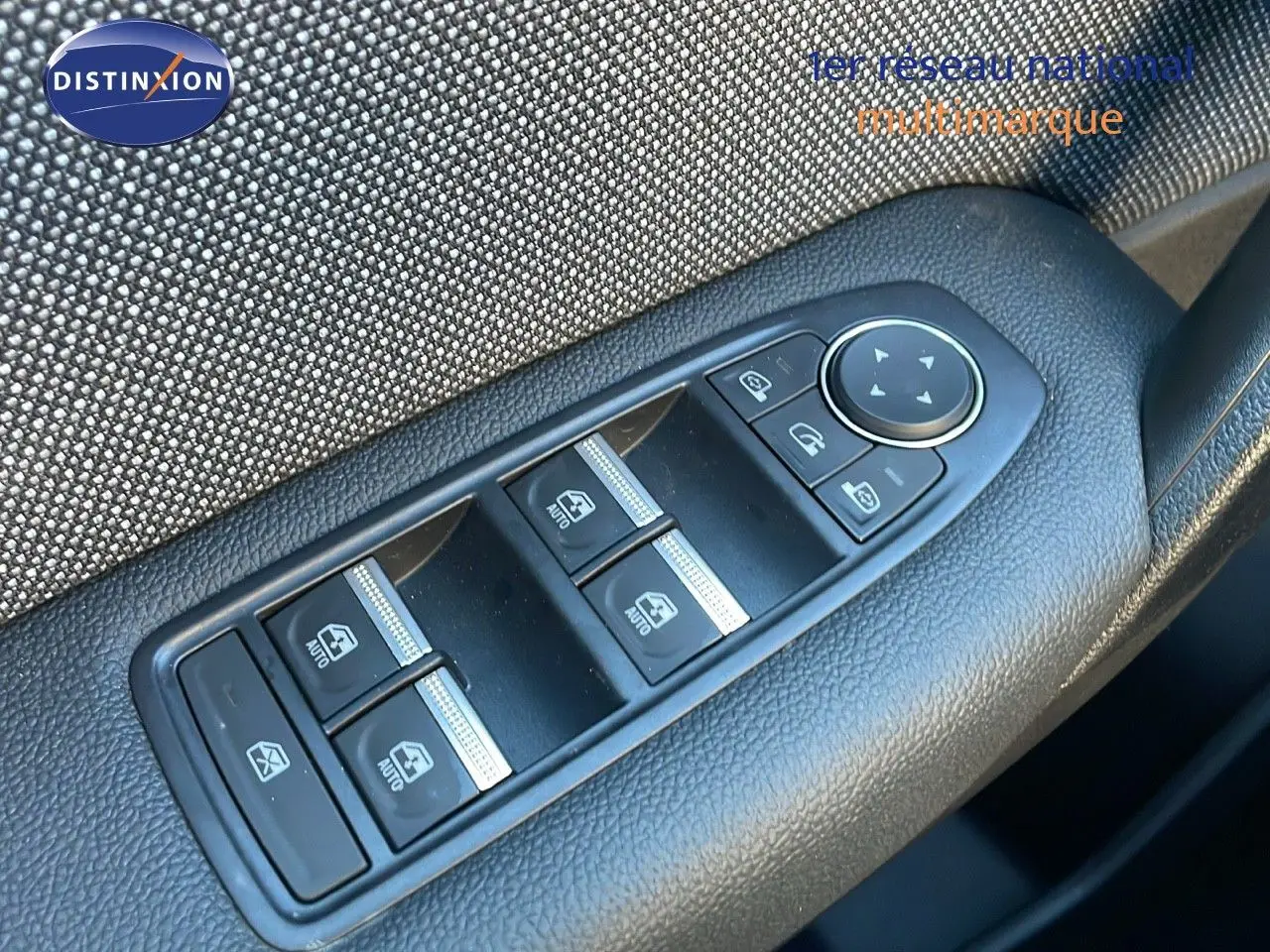 Gros plan sur les commandes des vitres électriques et rétroviseurs côté conducteur d'un Renault Captur 2025 bleu Iron Metal toit noir.