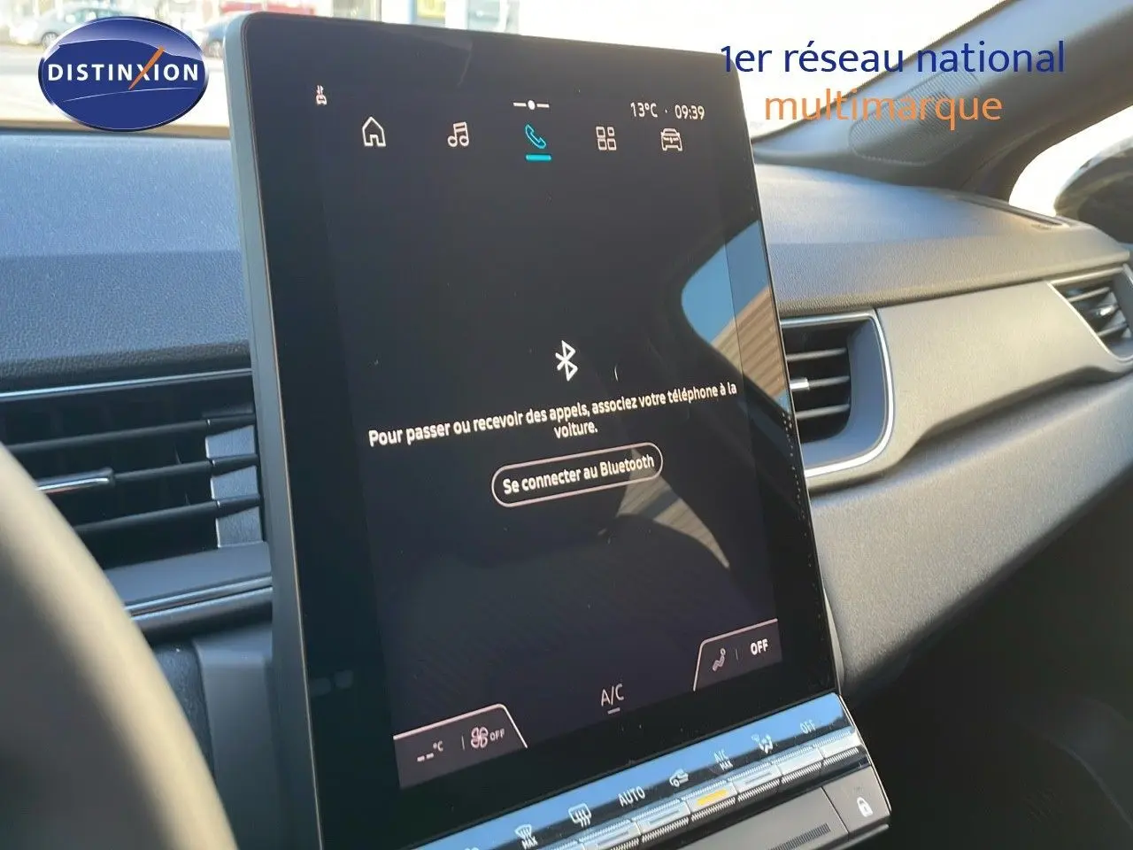 Écran tactile central allumé dans l'habitacle du Renault Captur E-Tech Hybrid 2025, ambiance intérieure moderne.