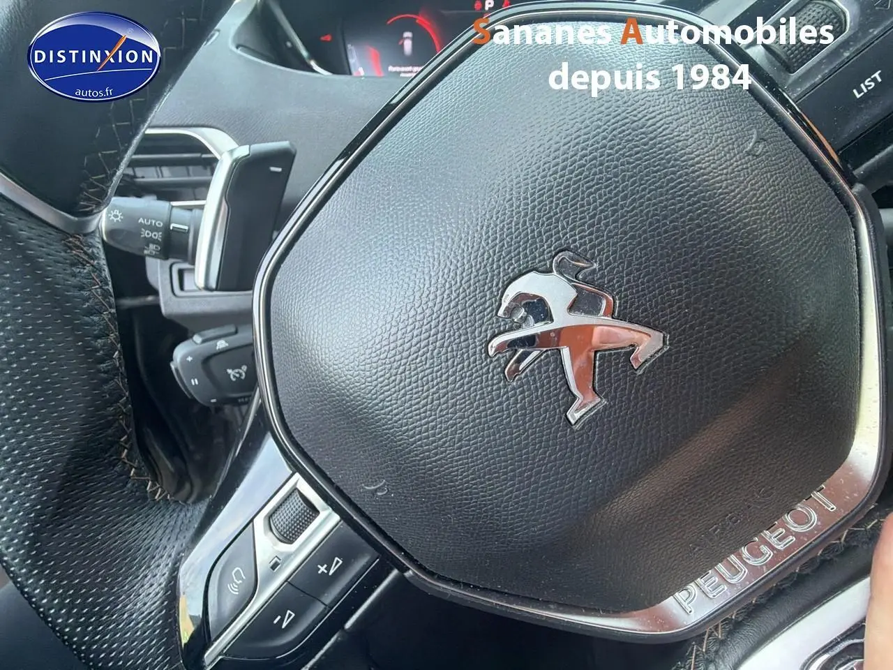 Gros plan sur le volant cuir perforé noir du Peugeot 3008 GT Pack Black, avec logo lion chromé au centre.