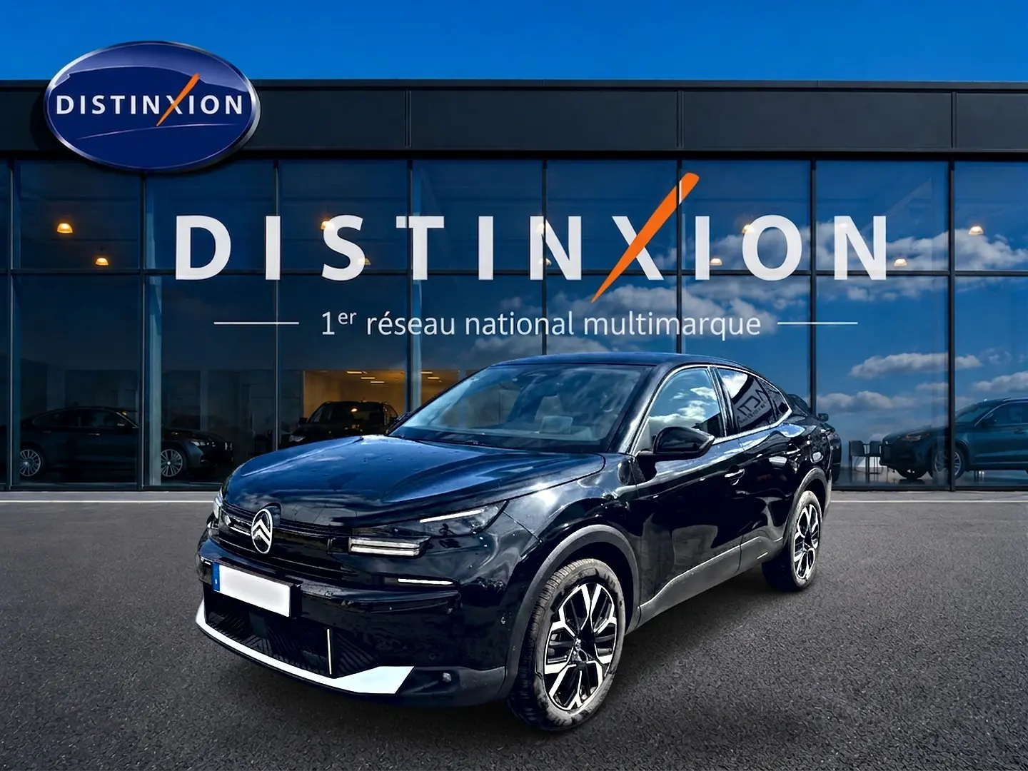 Citroën C4 X noir en 3/4 avant droit, avec jantes alu et calandre distinctive, devant une vitrine Distinxion.