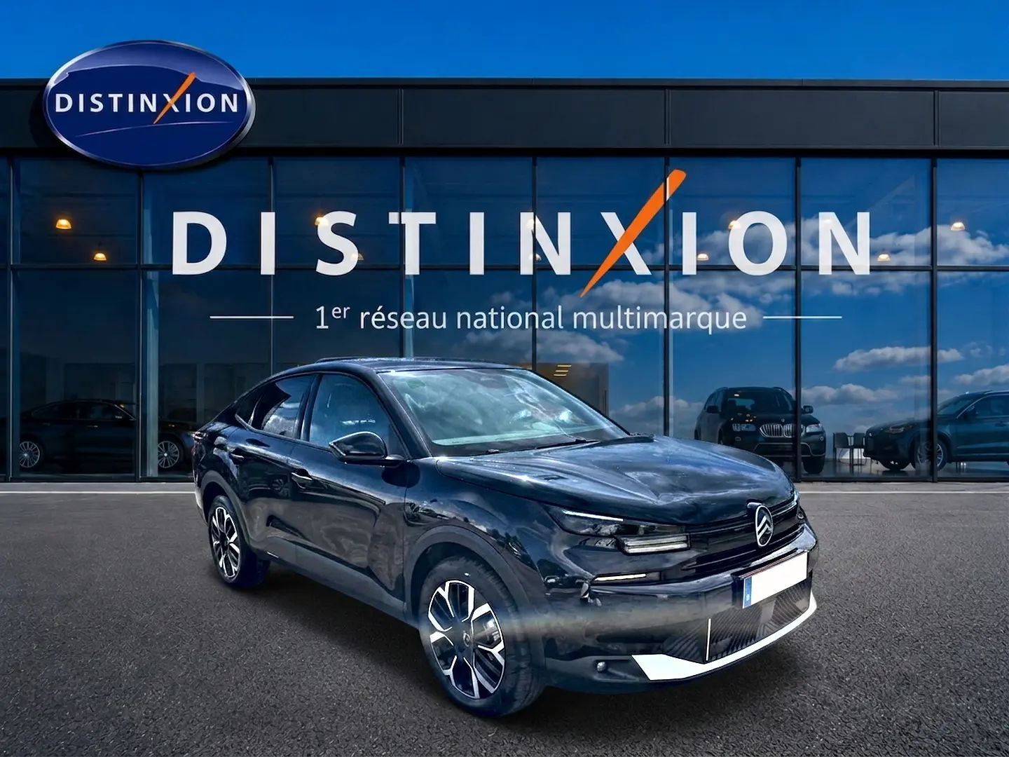 Citroën C4 X noir vue 3/4 avant droit, avec jantes alu distinctives, devant une vitrine Distinxion.