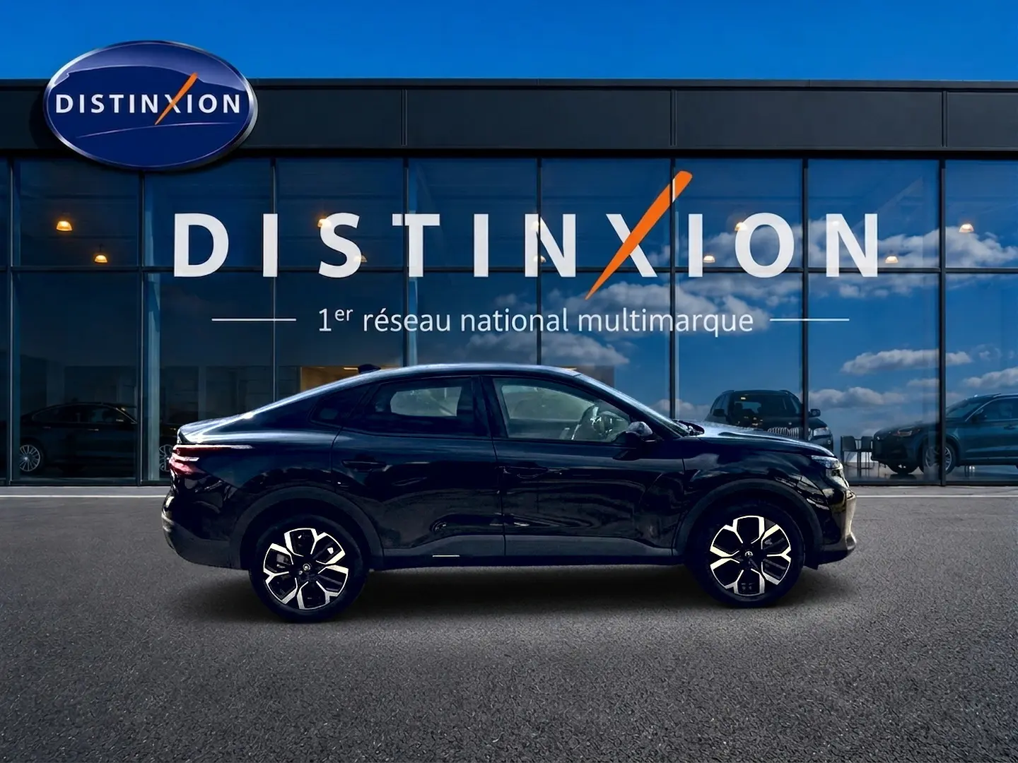 Profil côté gauche d'une Citroën C4 X noire 2025, avec jantes alu et silhouette élancée devant une vitrine Distinxion.