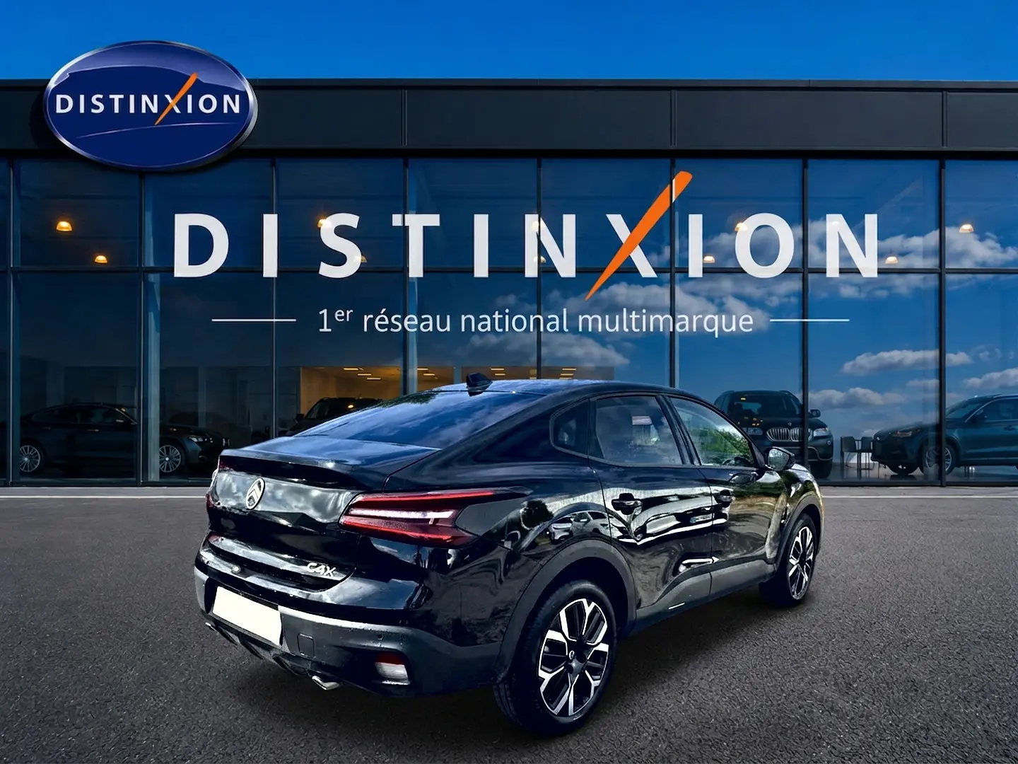 Vue 3/4 arrière droite d'une Citroën C4 X noire 2025 avec feux arrière LED et jantes alu distinctives.
