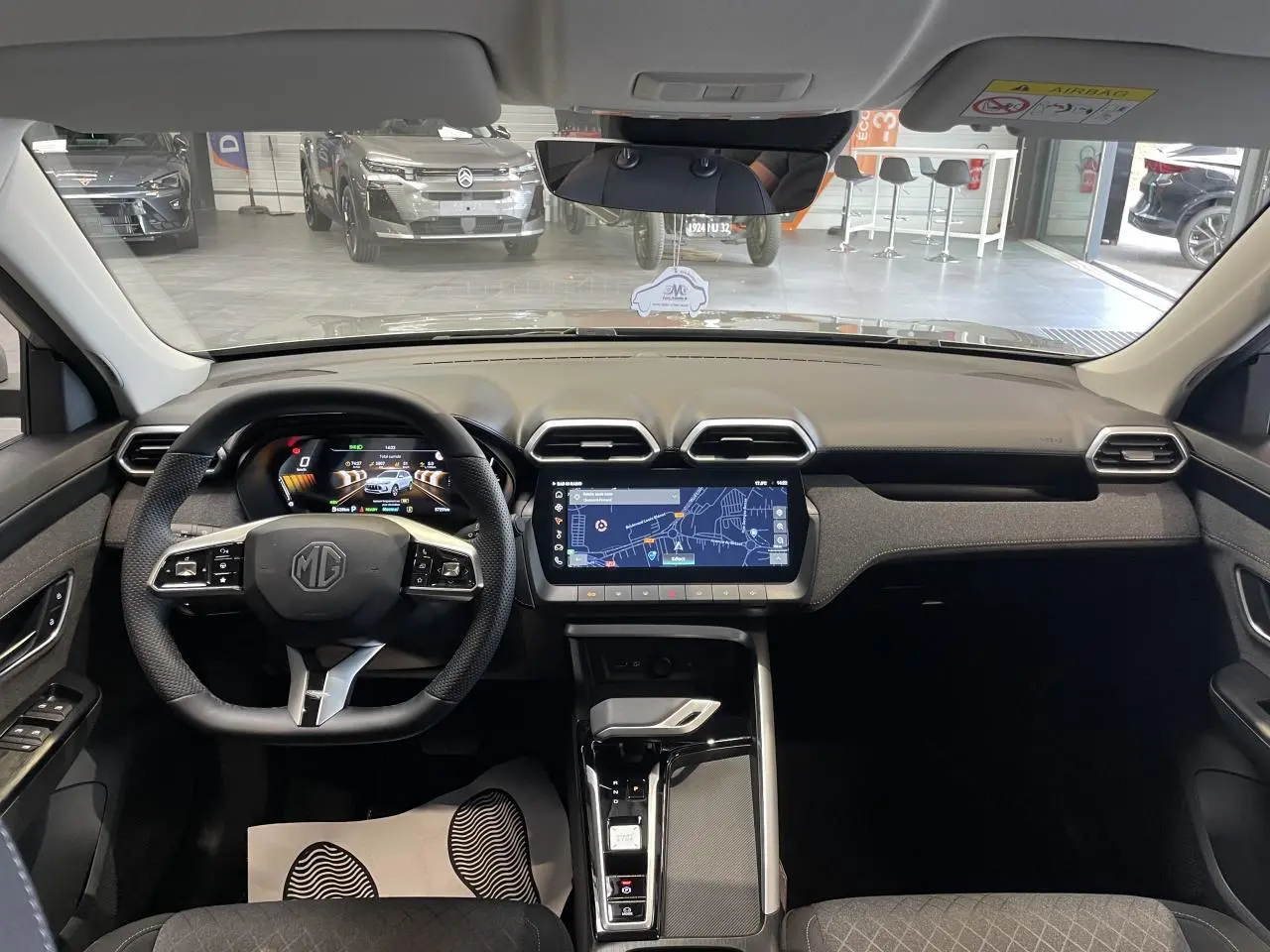 Vue intérieure frontale du MG ZS 1.5 Hybrid+ 2026 avec tableau de bord noir et écran tactile central affichant la navigation.