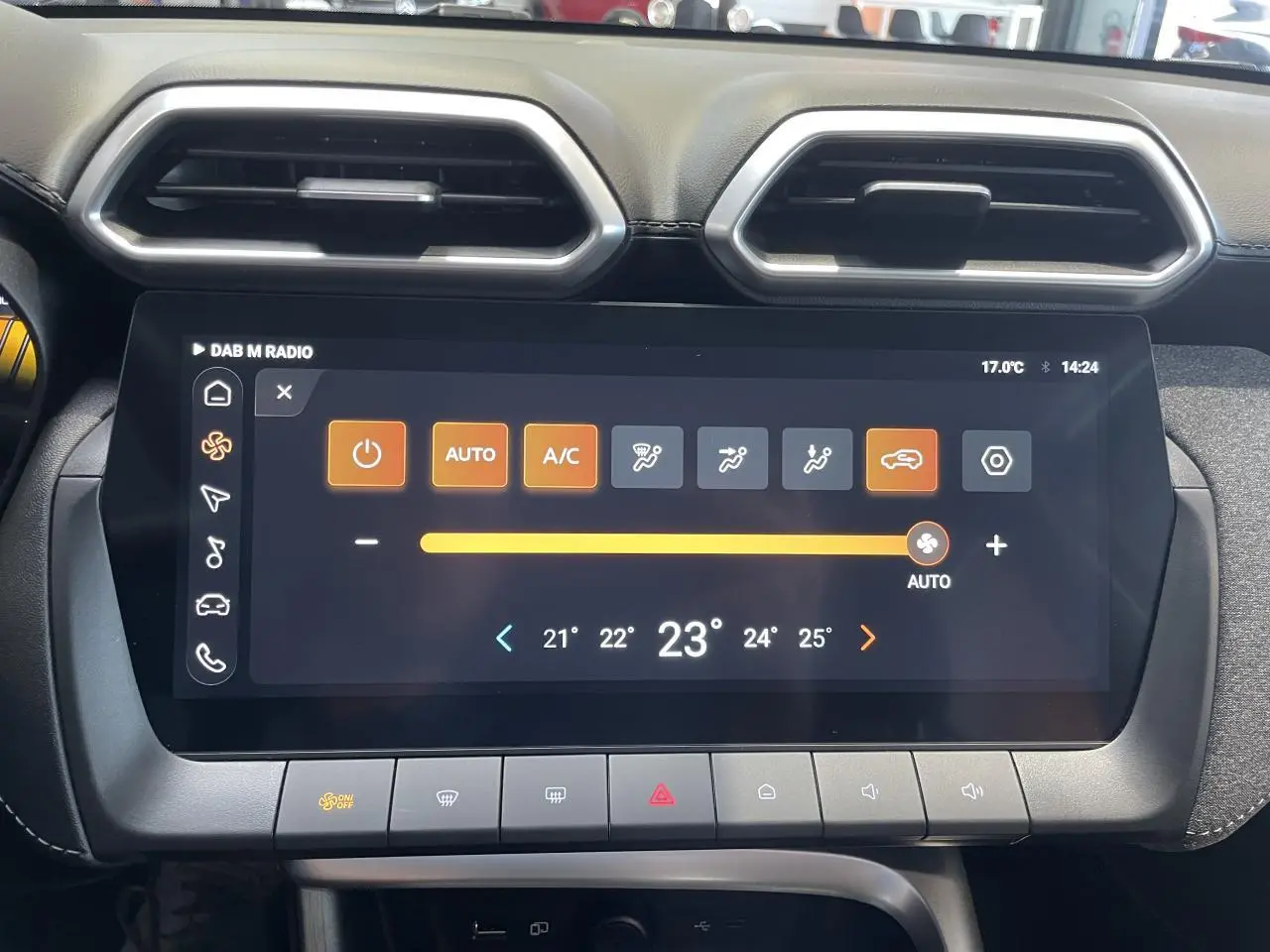 Écran tactile central du MG Motor ZS 1.5 Hybrid+ 2026, affichant la climatisation automatique, entouré de sorties d'air hexagonales.