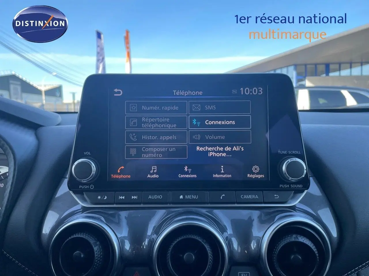 Écran tactile central du tableau de bord du Nissan Juke gris squale métal 2024, affichant le menu téléphone et connexions Bluetooth.