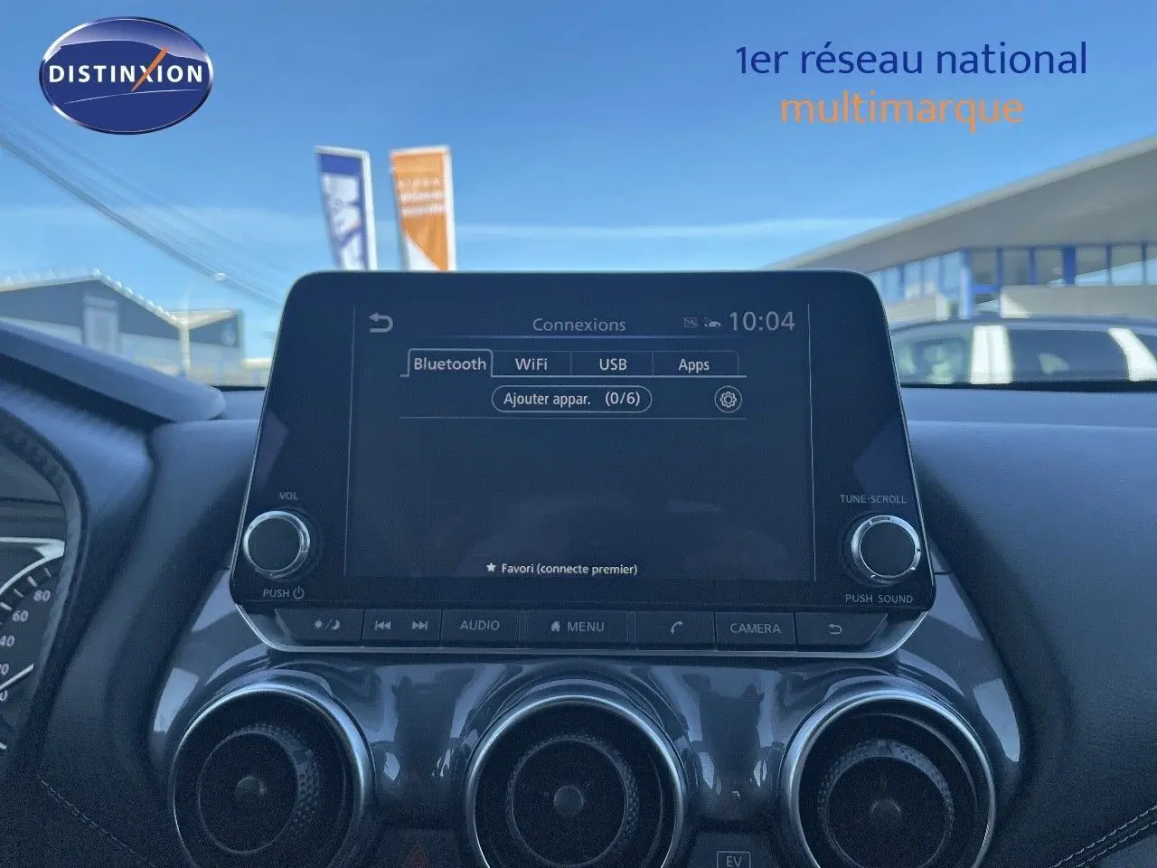 Tableau de bord du Nissan Juke 2024 avec écran tactile central et trois aérateurs ronds en finition gris métal.