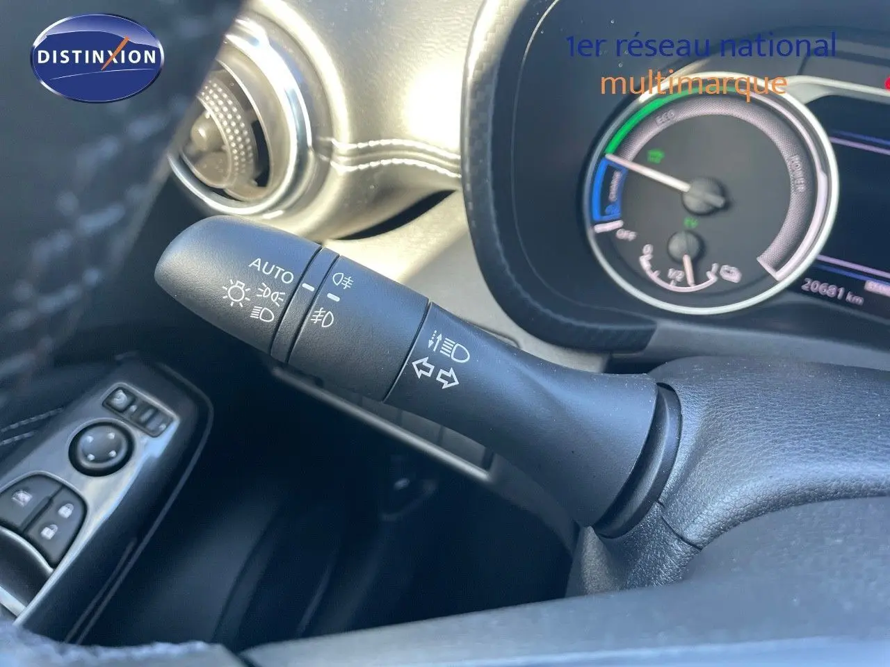 Gros plan sur la manette des phares et clignotants à gauche du volant dans l'habitacle du Nissan Juke gris 2024.