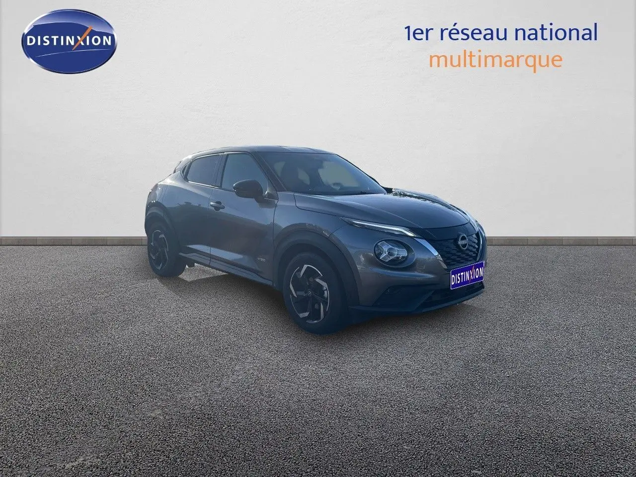 Nissan Juke gris squale métal en 3/4 avant droit, mettant en valeur ses lignes modernes et ses jantes bi-ton.