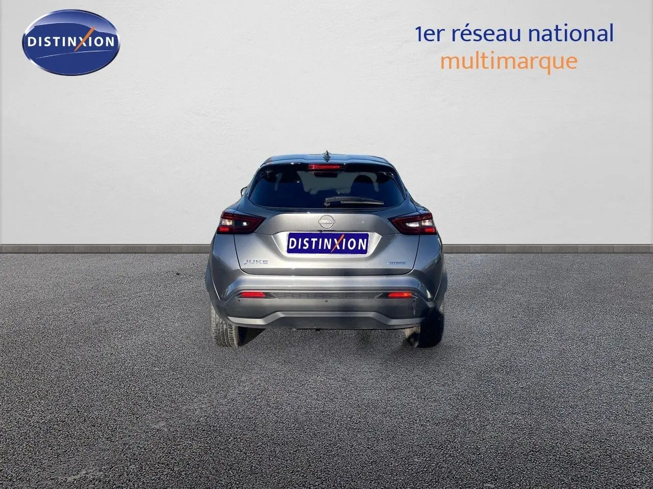 Vue arrière d'un Nissan Juke 1.6 HEV gris squale métal, mettant en valeur ses feux arrière et son design compact.