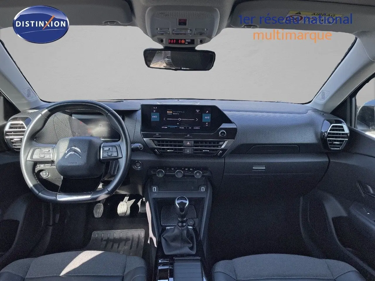 Vue frontale de l'intérieur noir du Citroën C4 2021 avec tableau de bord moderne et levier de vitesse manuel.