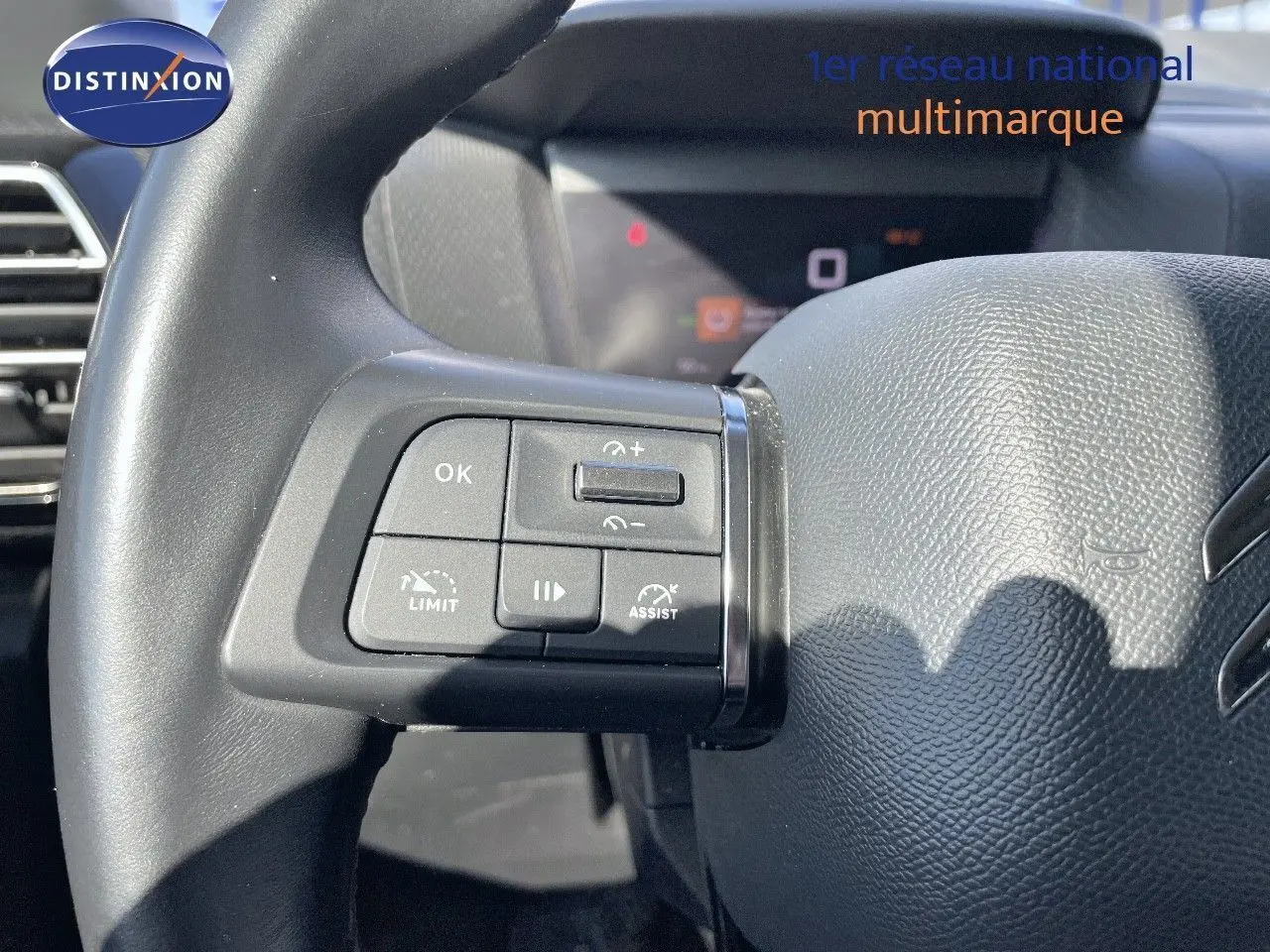 Gros plan sur le volant en cuir noir de la Citroën C4 avec commandes multifonctions à gauche visibles.