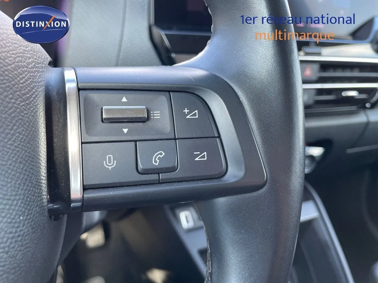 Gros plan sur les commandes au volant gauche d'une Citroën C4 2021 bleu Iceland Metal, intérieur moderne et épuré.