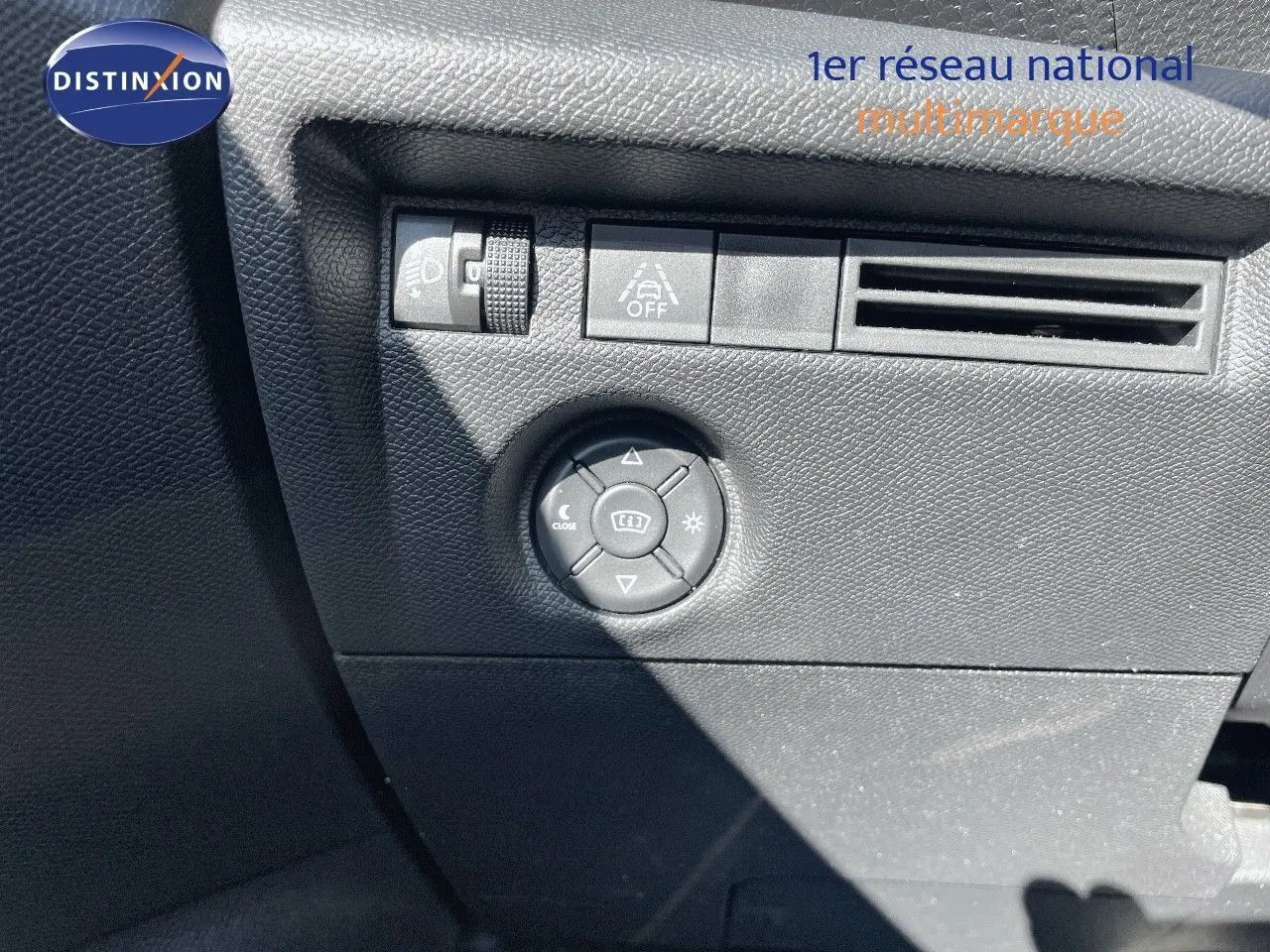 Gros plan sur les commandes de réglage des rétroviseurs et éclairage intérieur d'une Citroën C4 2021 noire.
