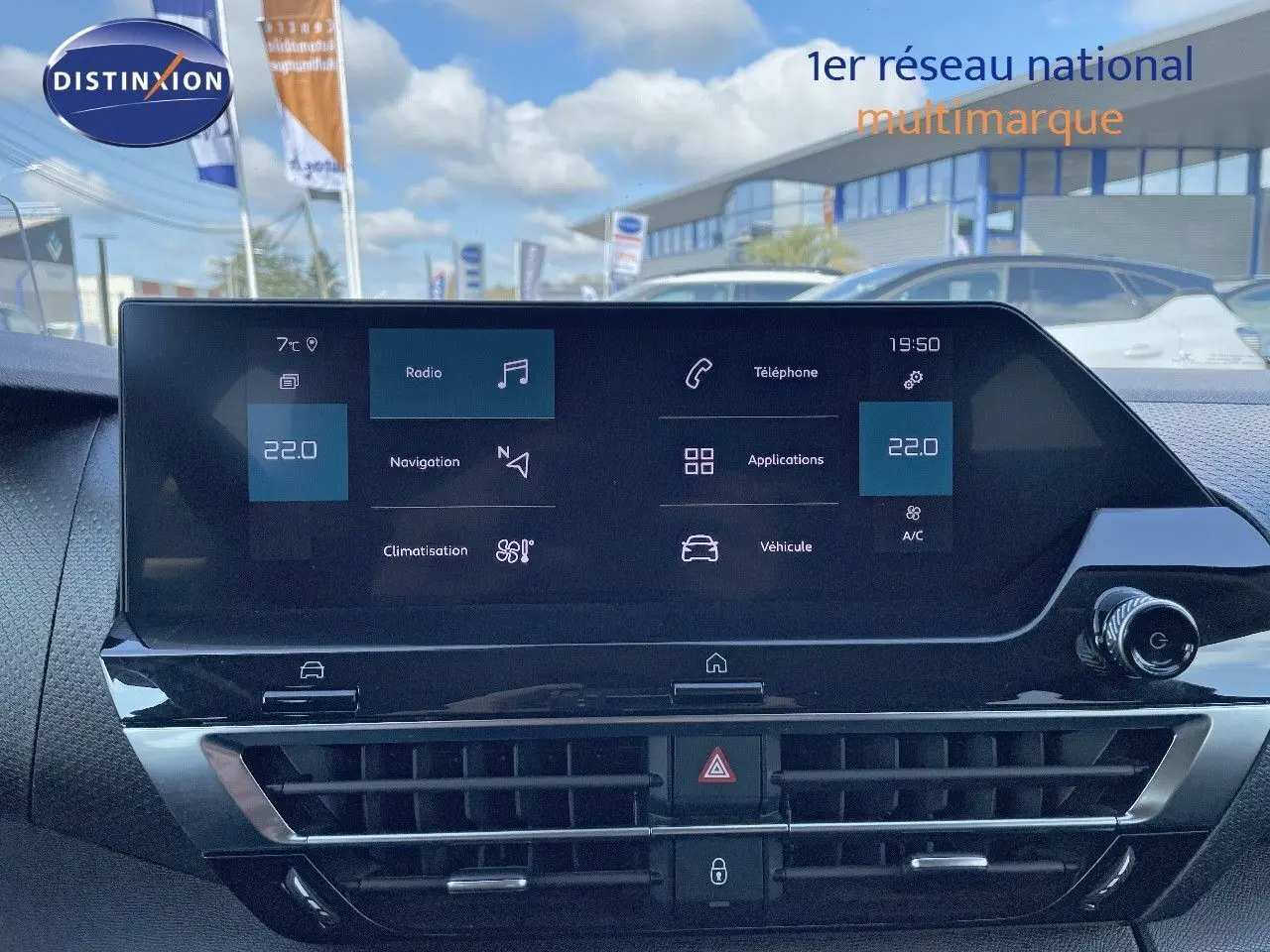 Vue rapprochée de l'écran tactile central du tableau de bord d'une Citroën C4 bleu Iceland Metal, affichant les options multimédia et climatisation.