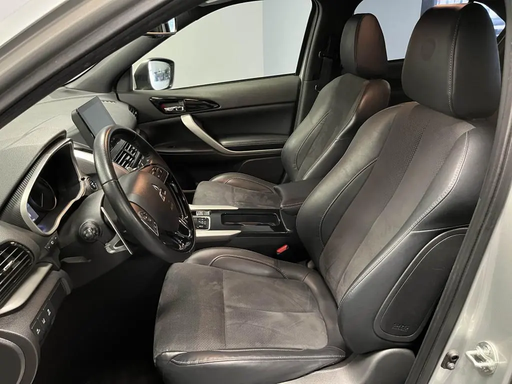 Intérieur avant du Mitsubishi Eclipse Cross gris, sièges en cuir noir et suédine, volant multifonction et écran tactile visible.