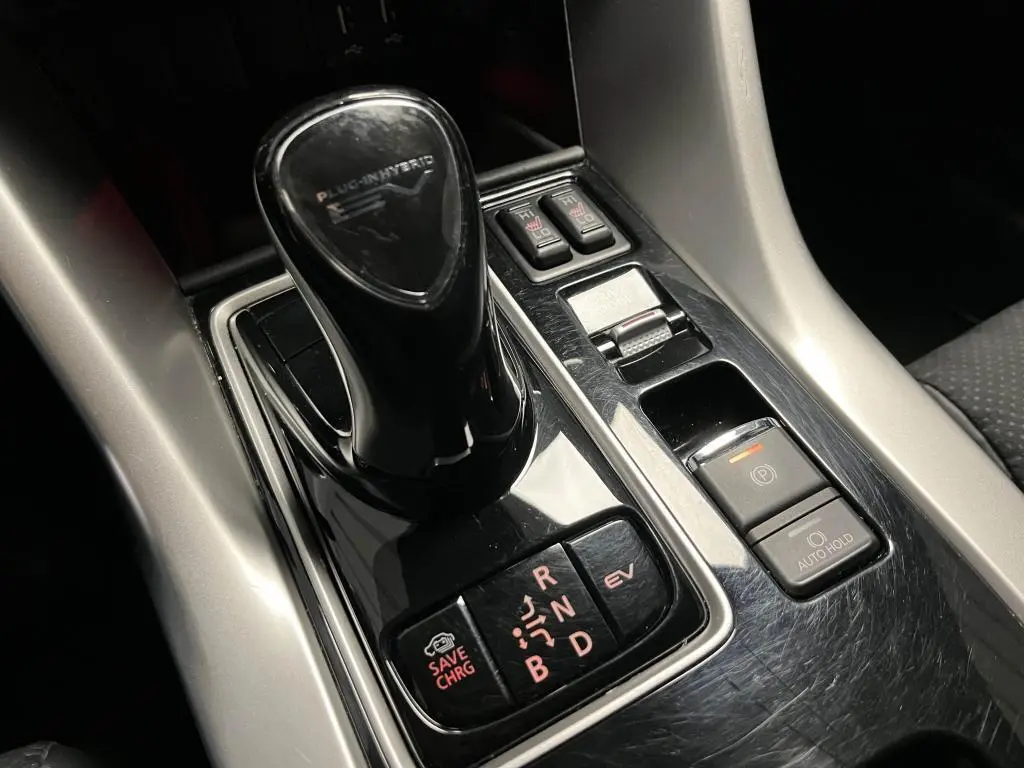 Le levier de vitesses noir brillant du Mitsubishi Eclipse Cross hybride rechargeable vu en gros plan sur la console centrale.
