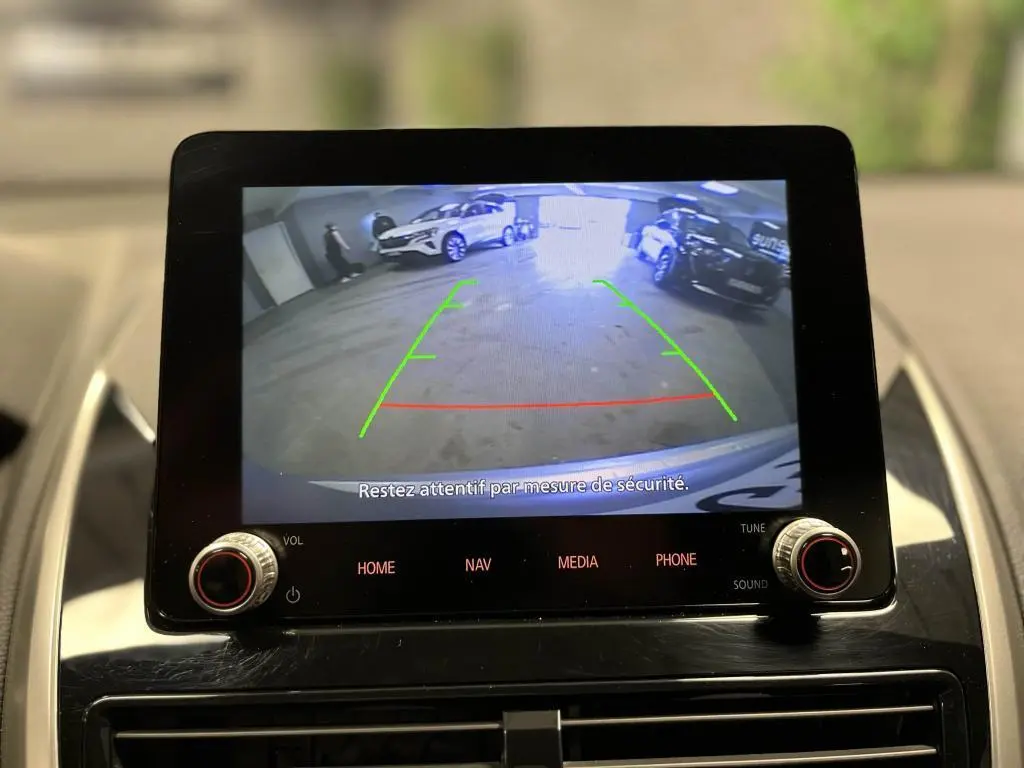 Écran tactile du Mitsubishi Eclipse Cross 2022 montrant la caméra de recul avec vue arrière sur parking intérieur.