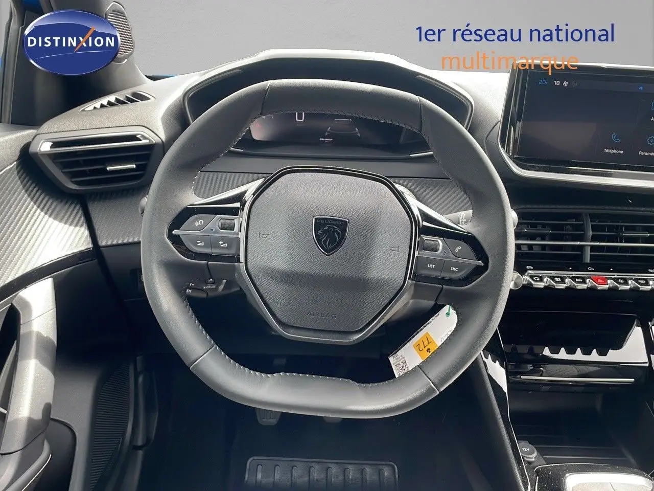 Vue rapprochée du volant multifonction noir du Peugeot 2008 2024 avec tableau de bord et écran tactile.