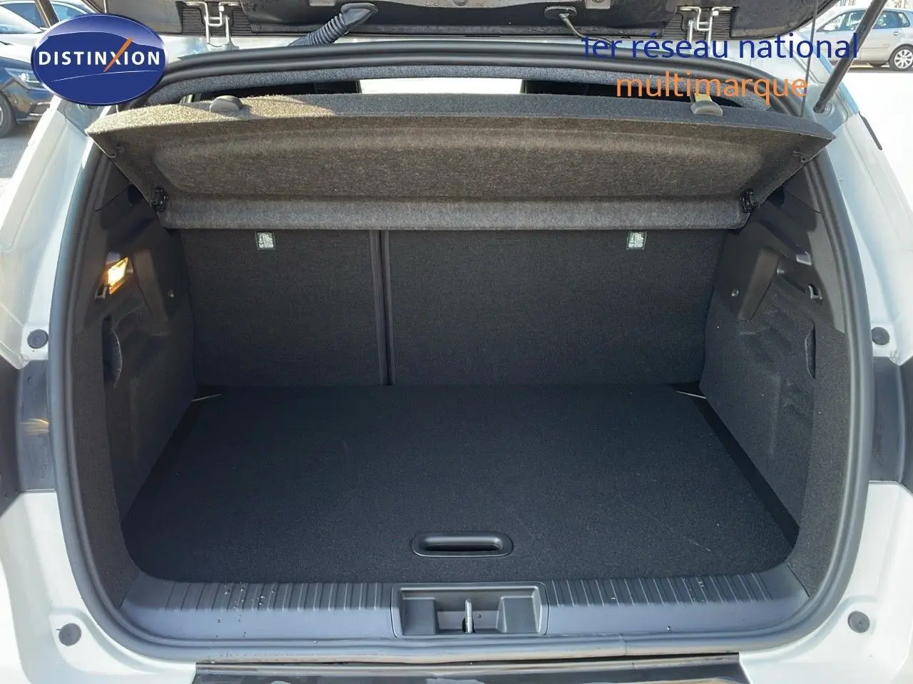 Coffre ouvert en vue arrière d'un Renault Captur blanc nacré avec toit gris, montrant un espace de chargement vide et propre.