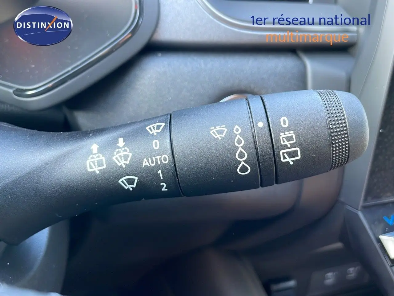 Gros plan sur la commande des essuie-glaces du Renault Captur blanc nacré au volant, intérieur gris.