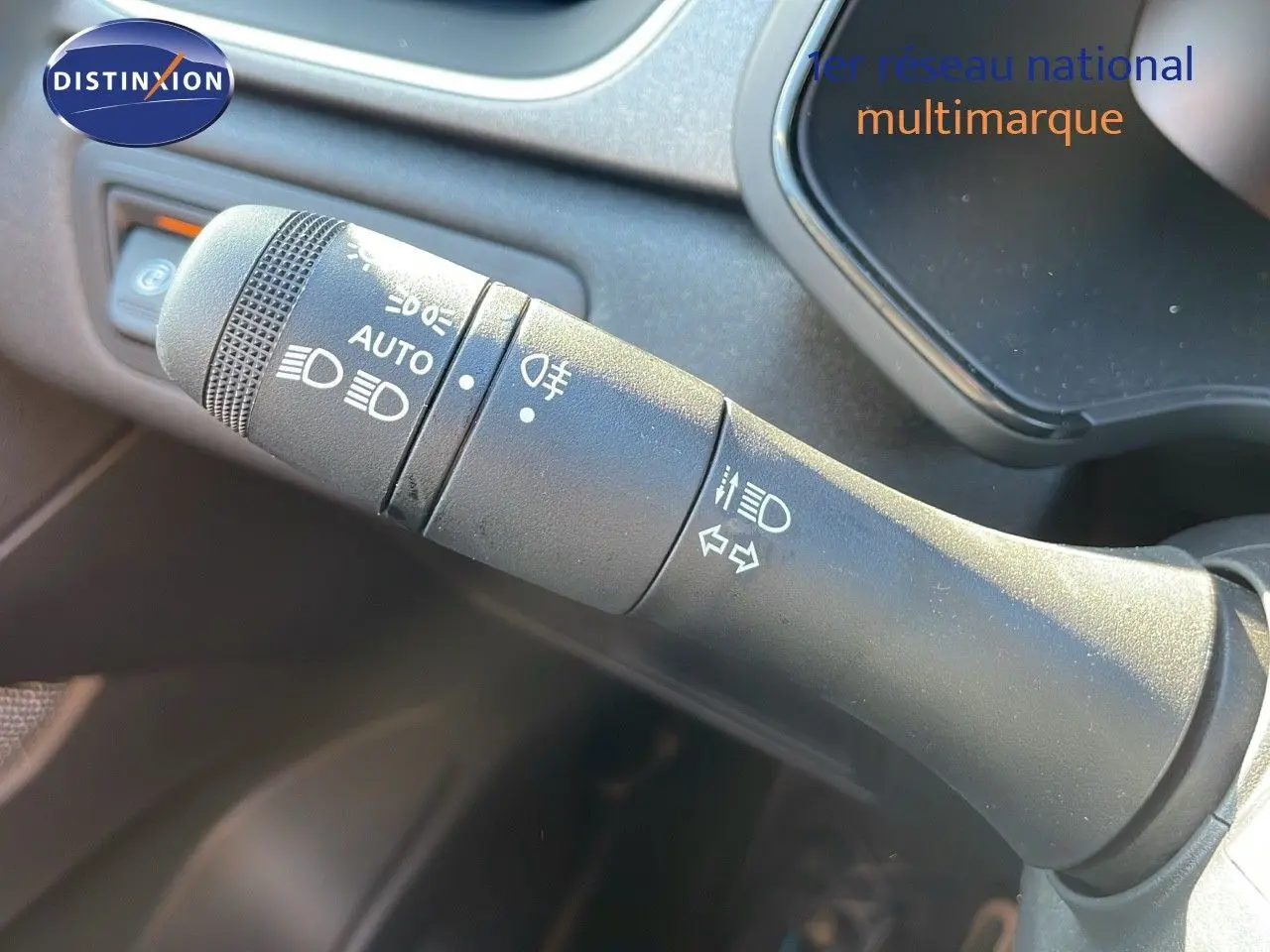 Gros plan sur la commande des phares et clignotants du Renault Captur E-Tech hybride blanc nacré, intérieur gris.