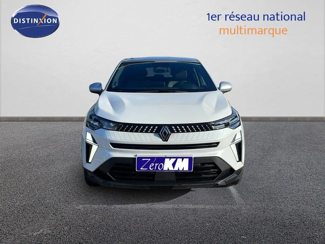 Vue frontale du Renault Captur E-Tech hybride blanc nacré avec toit gris, mettant en valeur ses feux LED et calandre moderne.