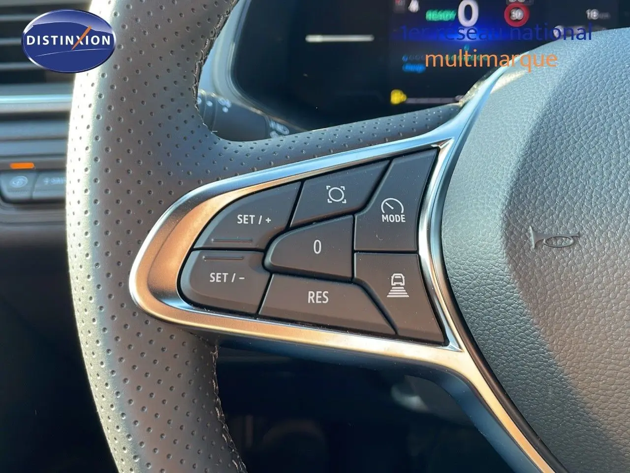 Gros plan sur les commandes de régulateur de vitesse au volant perforé du Renault Captur blanc nacré 2025.