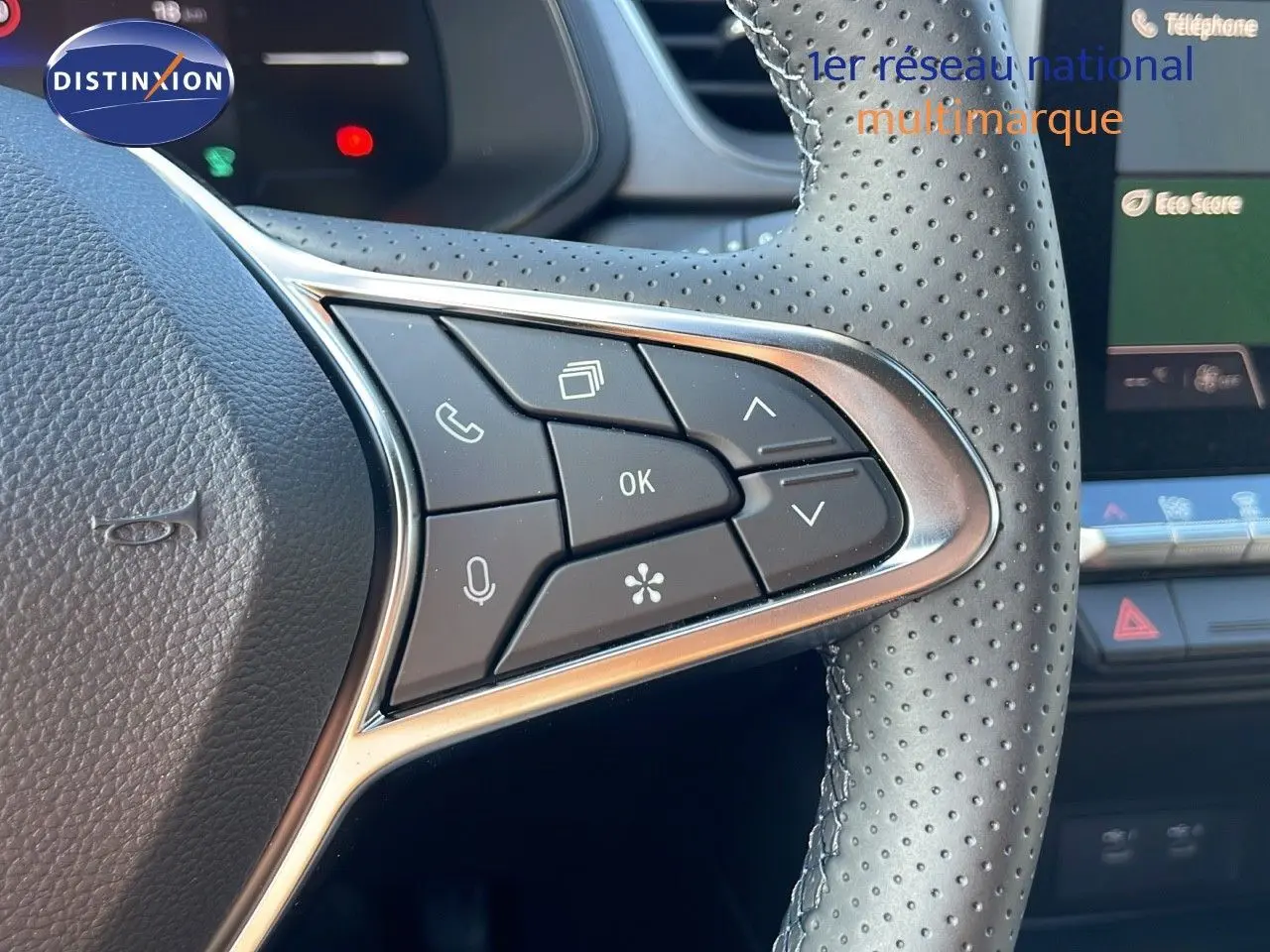 Gros plan sur les commandes multifonctions du volant perforé d’un Renault Captur E-Tech blanc nacré 2025, intérieur moderne.