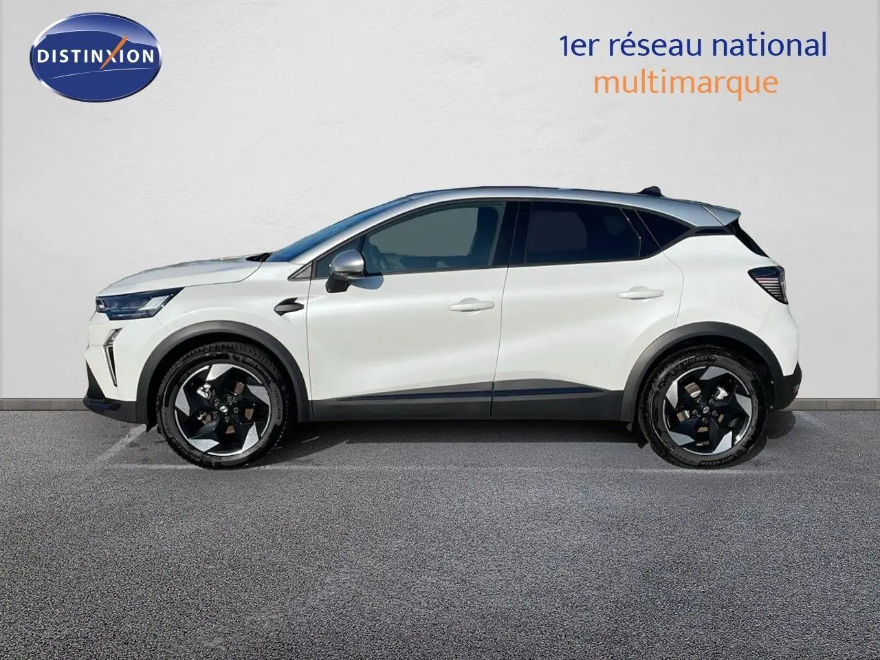 Profil côté gauche d'un Renault Captur E-Tech hybride blanc nacré avec toit gris et jantes noires 18 pouces biton.