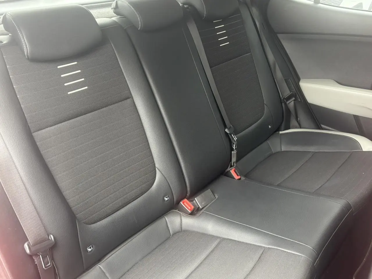 Vue rapprochée des sièges arrière noirs en tissu et cuir de la KIA Stonic, côté droit intérieur.
