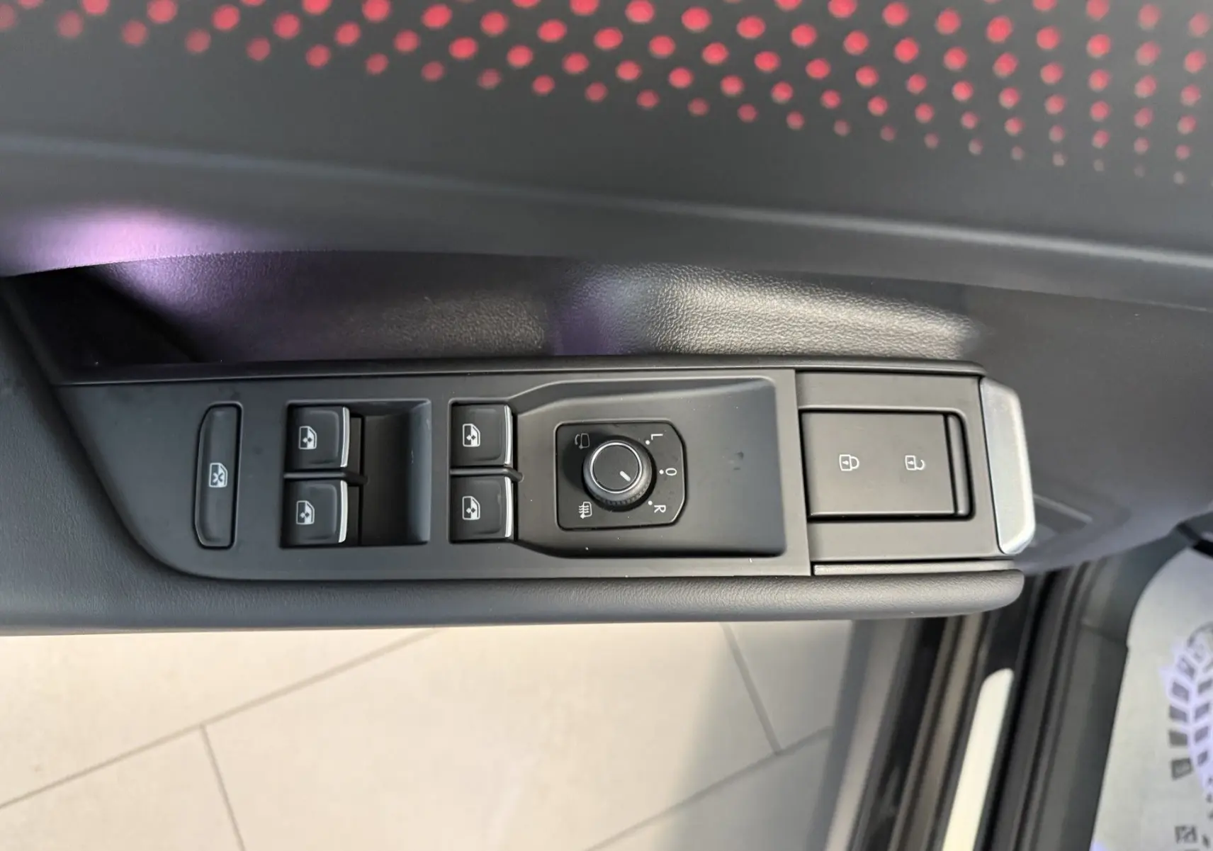 Gros plan sur les commandes de lève-vitres et réglage des rétroviseurs côté gauche du Volkswagen T-Roc noir intense 2026.