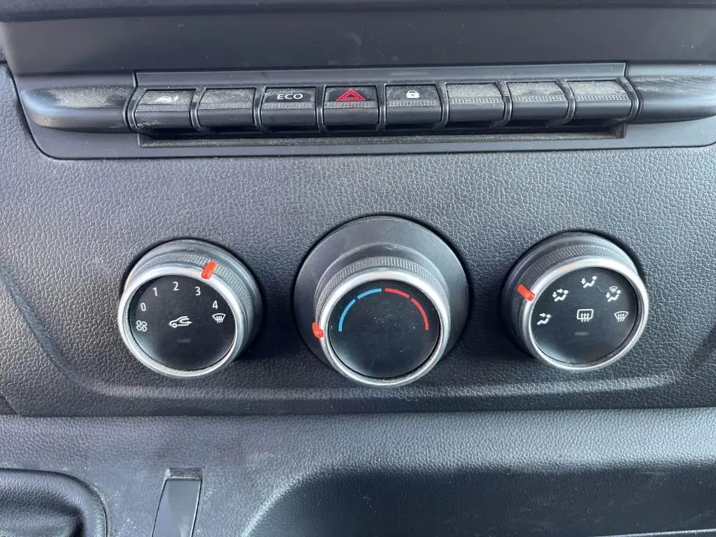 Gros plan sur les commandes de chauffage et ventilation du tableau de bord du Renault Master blanc, version Grand Confort 2020.